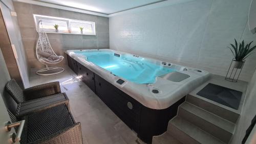 SeinsheimSchlaffass mit Wellness in alter Scheune的浴室配有大浴缸及椅子
