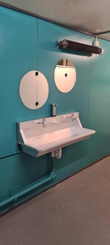 BurumBoerenchalet Dirk, Minicamping de Grutte Earen的浴室设有白色水槽和两面镜子