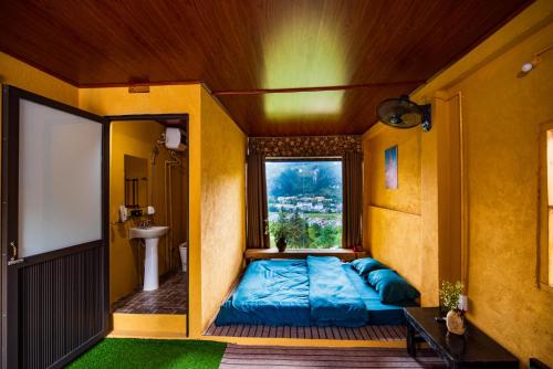 同文Đồng Văn Panorama Homestay的一间卧室设有蓝色的床和窗户。