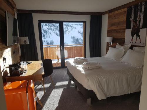 伊索拉2000Chalet Marano Restaurant & Spa的配有一张床、一张书桌和一扇窗户的酒店客房