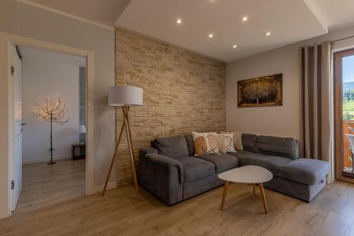 斯克拉斯卡波伦巴RentPlanet - Apartament Bawaria的带沙发和砖墙的客厅