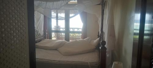 基利菲Vipingo beach villa的一间卧室配有一张带窗户的床