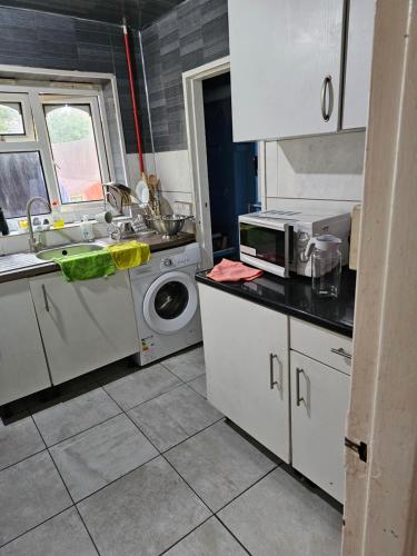 伯明翰3 bedroom flat的厨房配有水槽和洗衣机