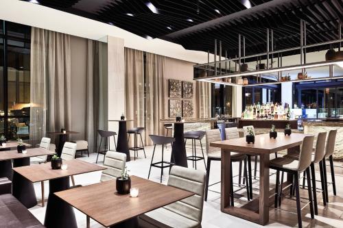 米苏拉AC Hotel by Marriott Missoula Downtown的一间带桌椅的餐厅和一间酒吧