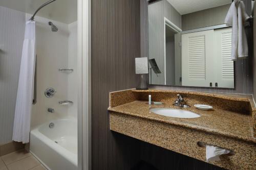 斯托克顿斯托克顿万怡酒店的浴室配有盥洗盆、镜子和浴缸