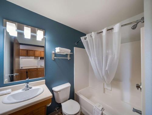 Trophy ClubWoodSpring Suites Fort Worth Trophy Club的一间带水槽、卫生间和镜子的浴室