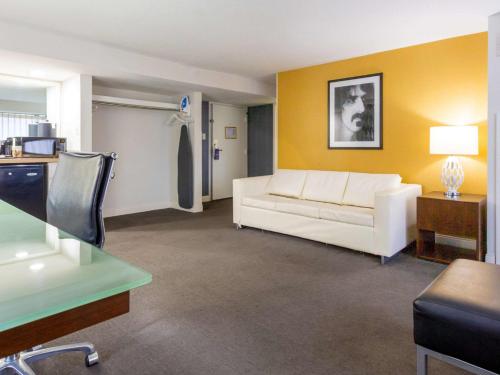 巴尔的摩Comfort Inn & Suites Baltimore Inner Harbor的客厅设有白色沙发和黄色的墙壁。