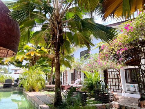 阿克拉奥玛殖民套房公寓的一个带棕榈树和游泳池的庭院
