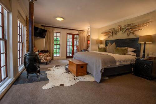 开普敦西尔弗米斯特葡萄酒庄园酒店的一间卧室配有一张床和一个燃木炉子