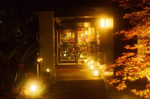 广野町Hotel Futabatei的夜间有灯的花店入口