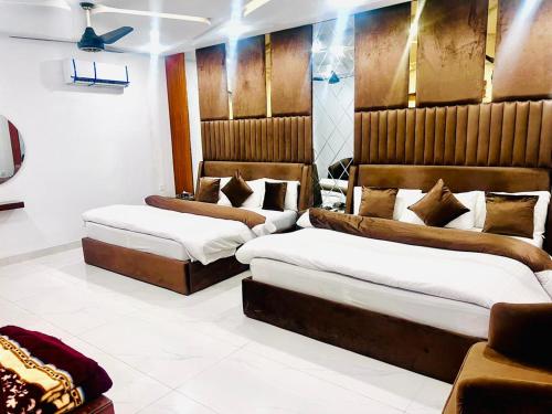 木尔坦The Signature Hotel Multan的一间带两张床和一张沙发的卧室