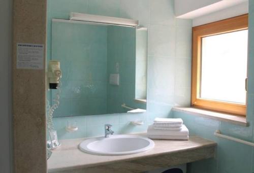 卡拉·利贝罗托Hotel Villa Campana的一间带水槽和镜子的浴室