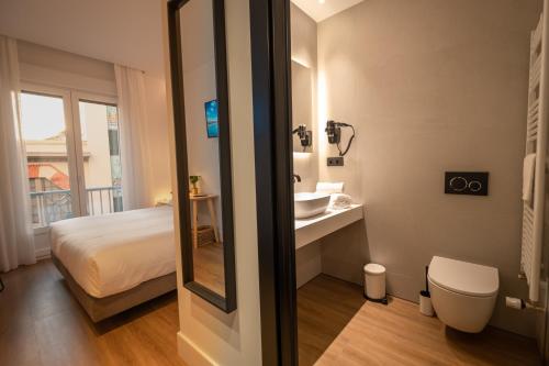 洛格罗尼奥PRINCIPE DE VERGARA ROOMS Lujo en el centro de Logroño的浴室设有床、水槽和镜子