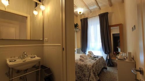 比博纳Residenza d'Epoca CAVALIERE的一间带水槽的浴室和一张位于客房内的床