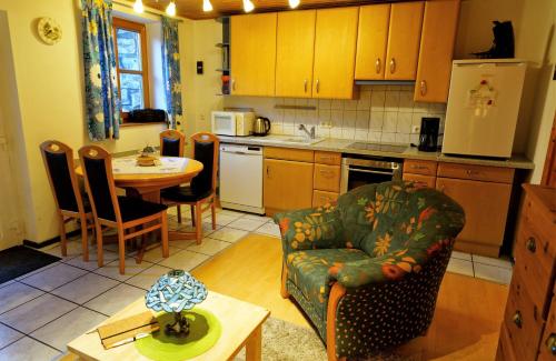 Neukirchen bei Sulzbach-RosenbergFerienwohnung Peuker的厨房配有桌子、沙发和椅子