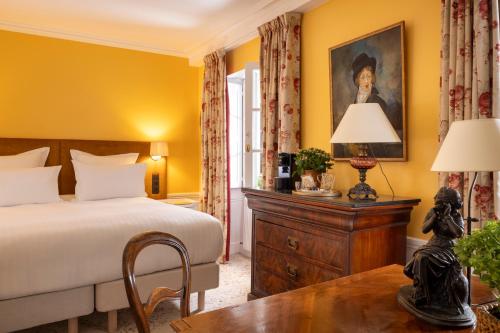巴黎圣格力格奥尔酒店的一间卧室配有一张床和一张带台灯的桌子