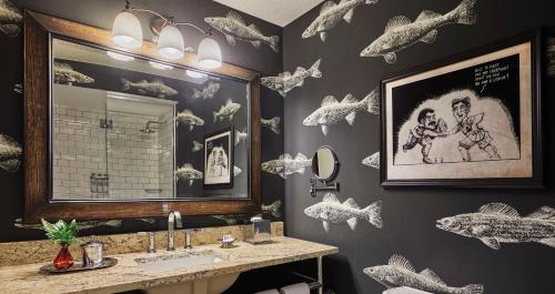 明尼阿波利斯明尼阿波利斯毕业生酒店的浴室设有水槽、镜子和墙上的鱼