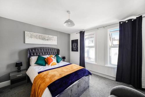 查塔姆A Stunning 3Bed house with WiFi的一间卧室配有带色彩缤纷枕头的床。