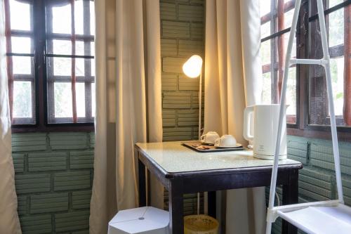 高兰Breeze Bungalows的一张小桌子,位于带两个窗户的房间