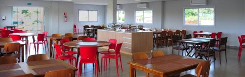 卡达斯诺瓦斯Casa Jardins da Lagoa的餐厅设有木桌和红色的椅子及桌子