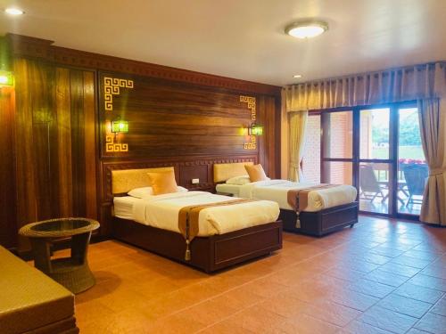 梅萨隆ดอยหมอกดอกไม้รีสอร์ท DoiMok DokMai Resort的酒店客房设有两张床和一个阳台。
