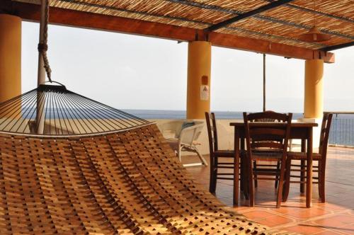 雷妮Albergo Seaside的天井上的吊床,配有桌椅