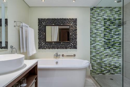 乌平通阿平顿万豪Protea酒店的带浴缸、水槽和镜子的浴室