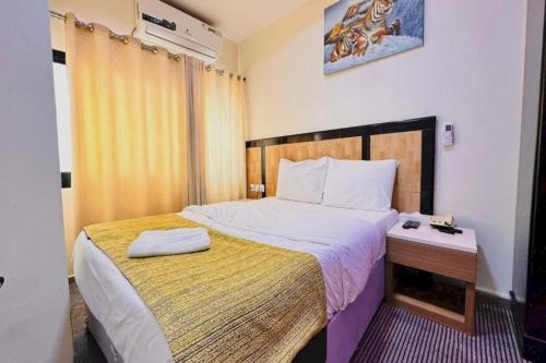 沙迦Sharjah Plaza Hotel的一间卧室配有一张带黄色毯子的大床