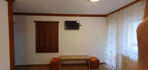 阿雷富Pensiunea Cota 1200 Piscul Negru的一间设有桌子和墙上电视的房间