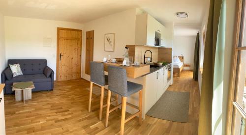 沼泽附近策尔Biohof-Feichtinger的厨房以及带沙发的起居室。