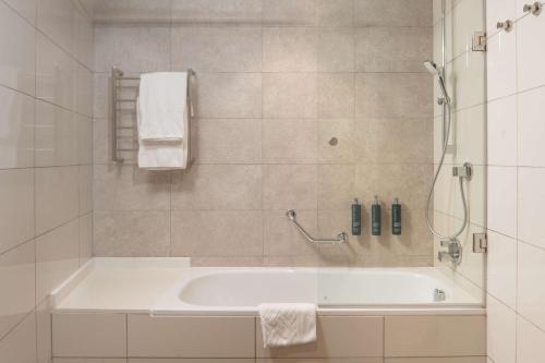 姆巴巴内Hilton Garden Inn Mbabane的白色的浴室设有浴缸和淋浴。
