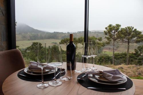 邦雅尔丁-达塞拉Jardim das Pedras的一张桌子,上面放着一瓶葡萄酒和眼镜