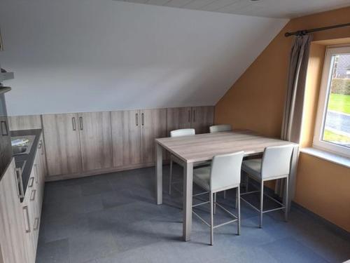 巴斯托涅L'Etable d'Evelyne的厨房配有木桌和白色椅子