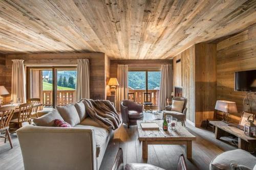 拉普拉涅1800Odalys Chalet Sporting Lodge的客厅配有沙发和桌子