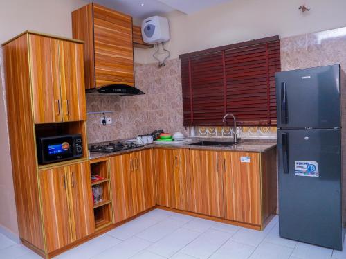 乌约E&T Luxury Apartments的厨房配有木制橱柜和冰箱。