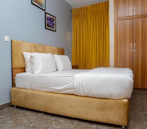 乌约E&T Luxury Apartments的一间卧室配有一张带白色床单的大床