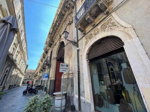 卡塔尼亚Sleep Inn Catania rooms - Affittacamere的商店前有停车标志的建筑物