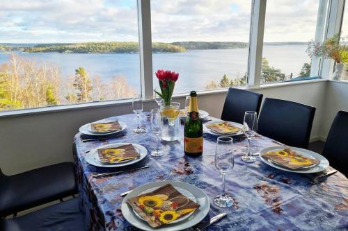 TyresöVilla Stockholms skärgård 30 min från Stockholm centralt的餐桌,带食物盘和一瓶葡萄酒