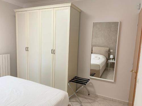 FolignanoLa Casetta的卧室配有白色橱柜和镜子