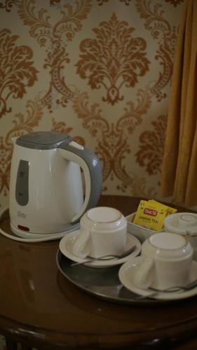 沃诺索博Le Desa Resort Syariah的茶壶和桌上的碟子