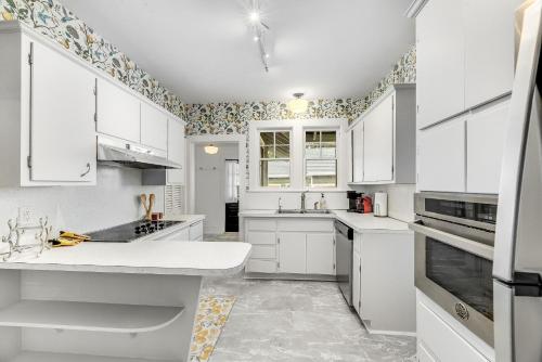 墨尔本Noi Nest Home + Pool + Suites的白色的厨房配有白色橱柜和电器