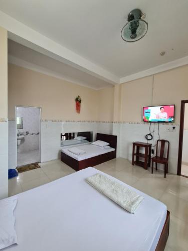 Ðông HòaKhách sạn Dạ Lan的一间卧室配有一张床和一台平面电视