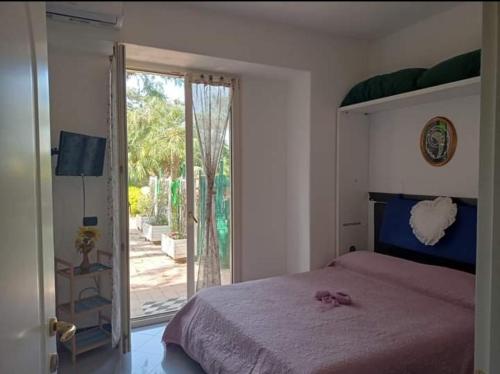 伊斯基亚Casa Sonia的一间卧室设有一张床和一个滑动玻璃门