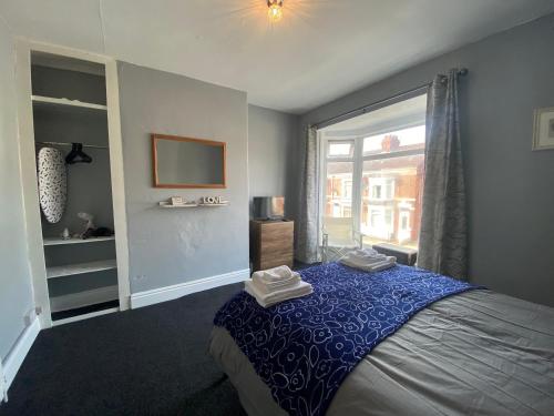 赫尔Cosy and Comfortable Newly Refurbished Family Home的一间卧室配有一张带蓝色毯子的床和窗户。