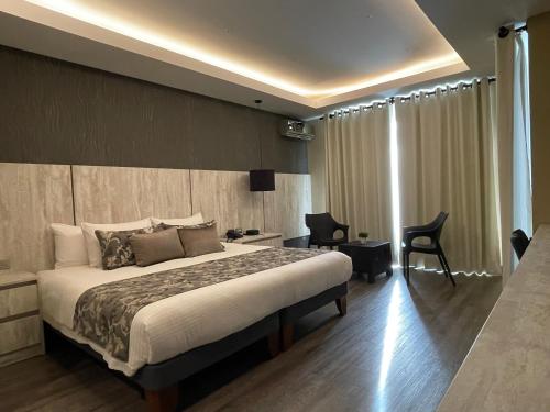科恰班巴Hotel Catena的酒店客房,配有一张床、一张桌子和椅子