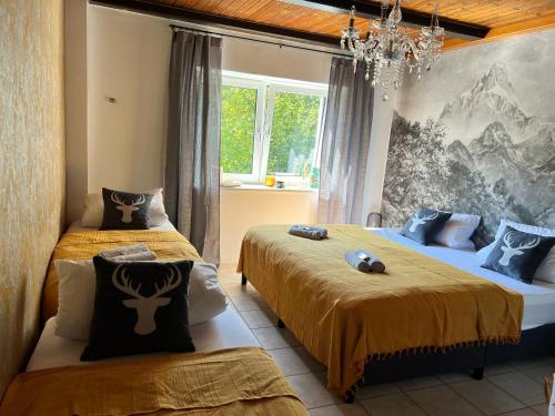 洛贝格Bavaria Mountain Lodge SKI Arber Osser Bayrischer Wald DESIGNER Ferienwohnung的一间卧室配有两张床和吊灯。