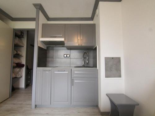 拉普德兹Appartement Huez, 1 pièce, 3 personnes - FR-1-405-87的厨房配有白色橱柜和水槽