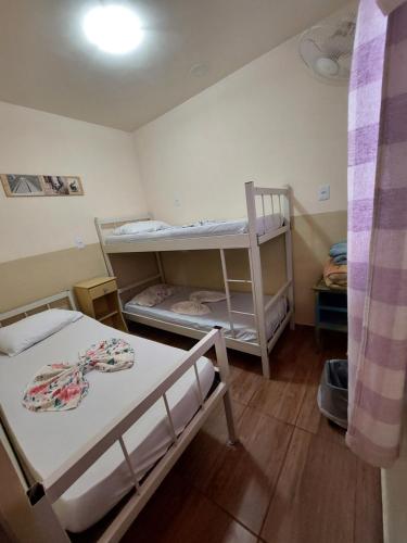 贝洛奥里藏特Hostel BH的一间小房间,内设两张双层床