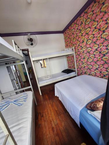 贝洛奥里藏特Hostel BH的一间卧室设有两张床和鲜花墙