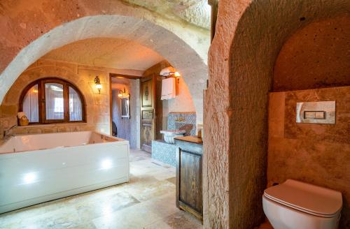 NarCAPPANAR CAVE HOTEL的带浴缸和卫生间的浴室。